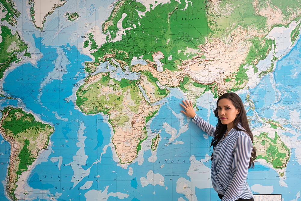 Educator in Front of the World Map of Destinations