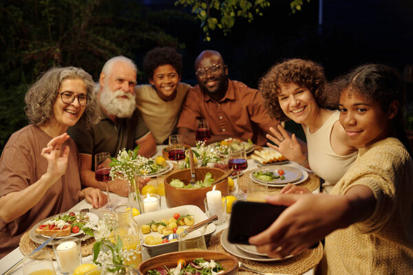 Family looking at smartphone screen while communicating with their friends.